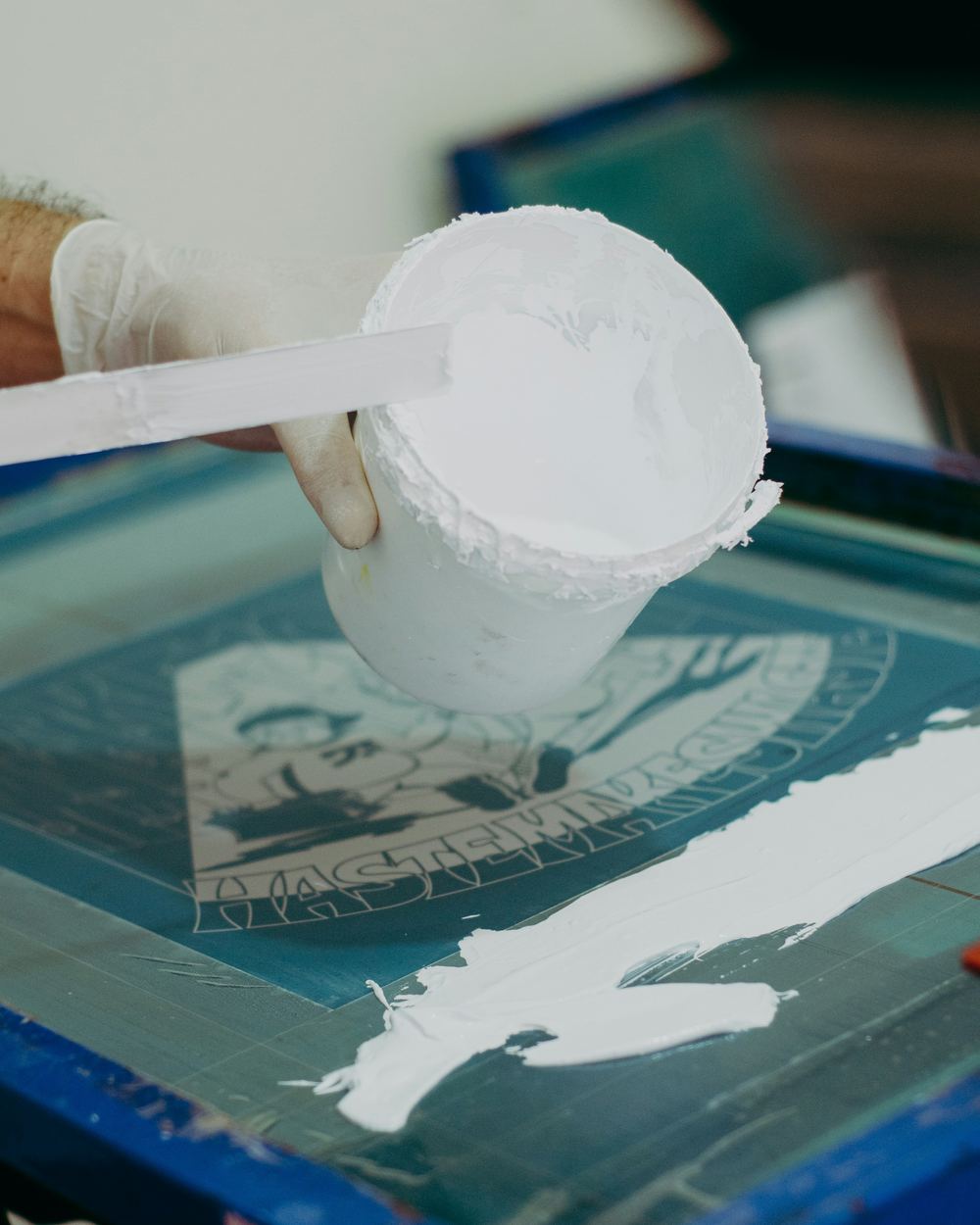 Screen printing squeegee pulling ink across a screen in the Accelerate Brand Studio workshop