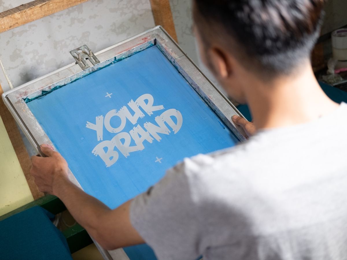 Accelerate Brand Studio team member holding a freshly screen printed brand panel